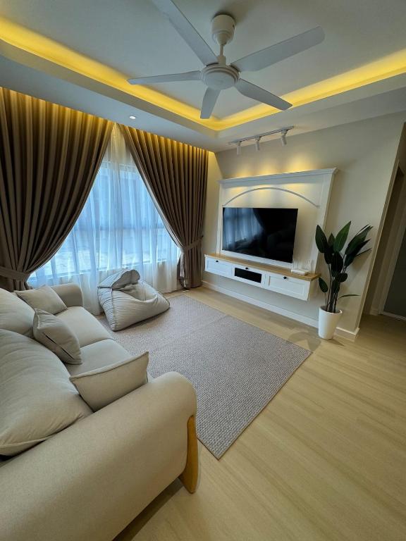 a living room with a white couch and a flat screen tv at InapByDaddy's Near KLIA SIC Sepang 4BR Fully Aircond in Sepang