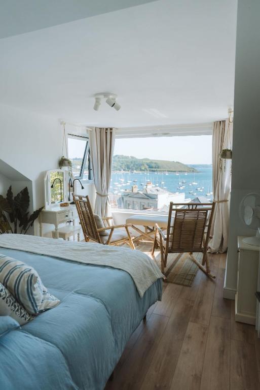 a bedroom with a bed and a view of the water at Tide View Townhouse - By Rowes Retreats in Falmouth