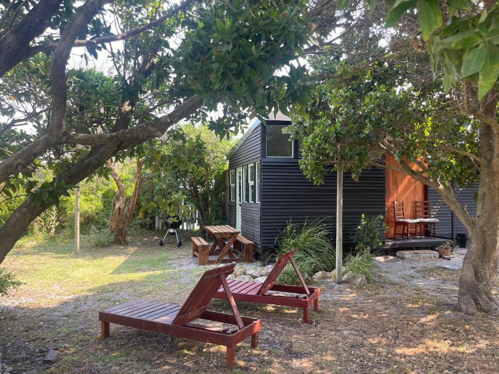 a group of benches in front of a cabin at Waterberry Hideaway in Pringle Bay