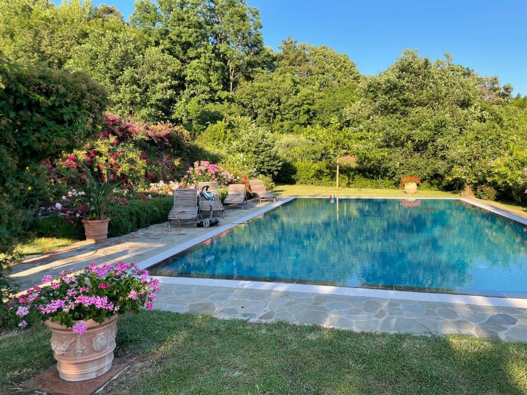 a swimming pool in a yard with flowers at La Casa Gialla in Lucca