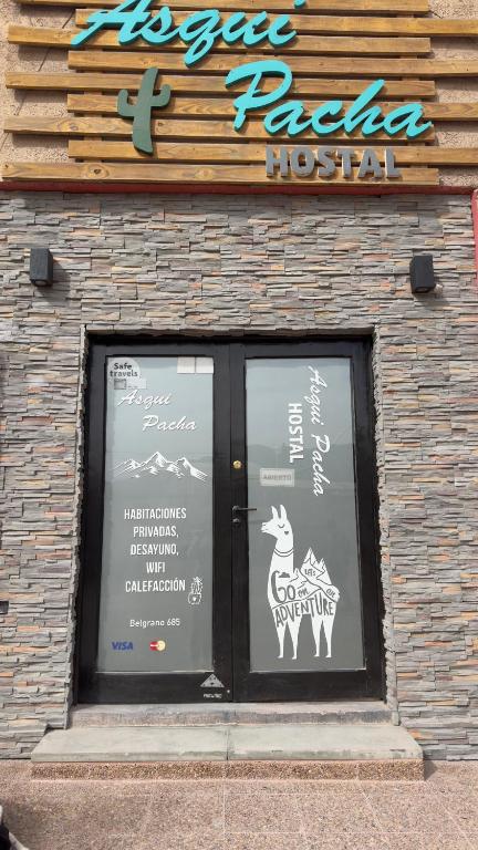a window of a pizza hut with signs on it at Hostal Asqui Pacha in Tilcara