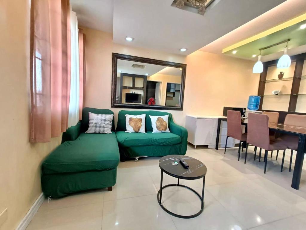 a living room with a green couch and a table at One Oasis Condo beside SM Mall in Davao City