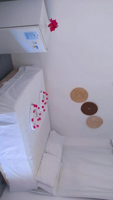 a room with a white bed with red hearts on it at Pousada recanto do sol in Cajueiro