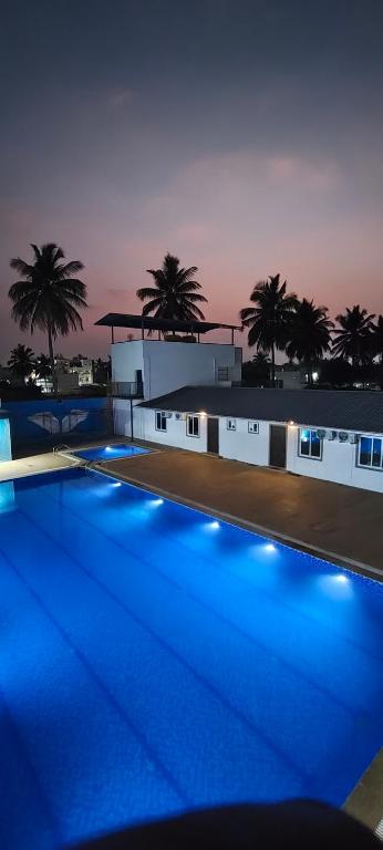 a swimming pool with blue lights in front of a building at Flying Fox in Bangalore