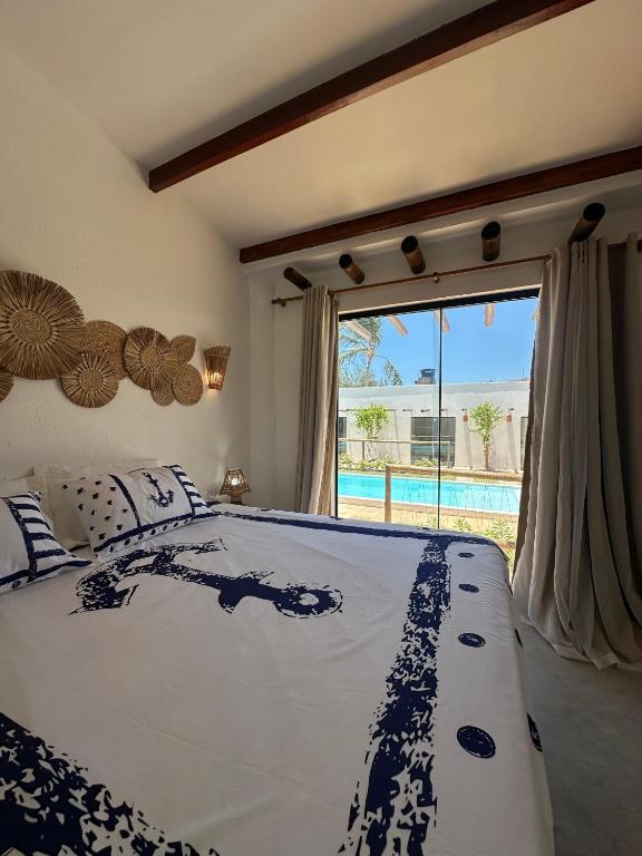a bedroom with a bed with a view of a pool at BaleiaLofts Kite Village in Itapipoca