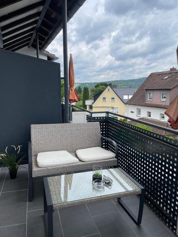 Balkon mit Sitzgelegenheit und Glastisch