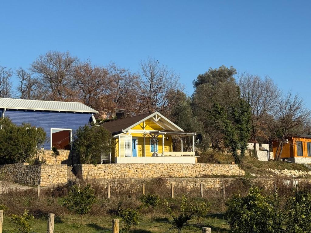 a house with a yellow door and a stone wall at La Belle Saison in Briska Gora
