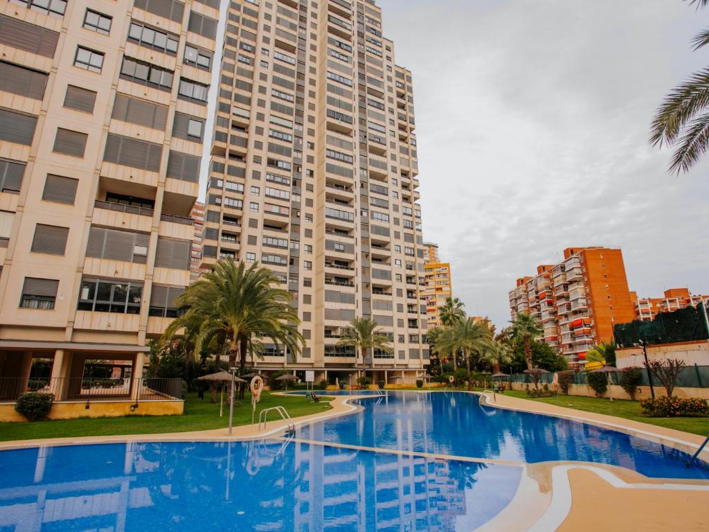 a swimming pool in front of a tall building at Apartamento Gema Gemelos 26 in Benidorm