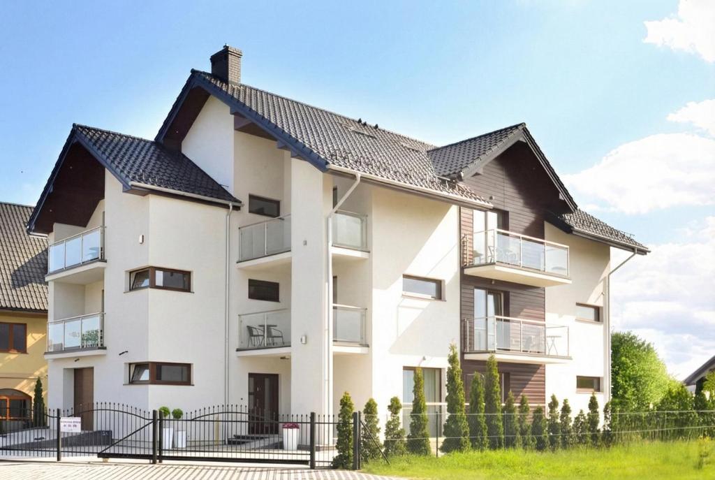 a white building with a black roof at HORN Jastarnia in Jastarnia