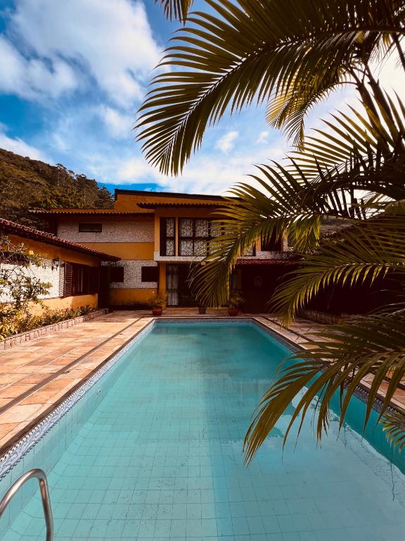 a swimming pool in front of a house at Mansão Bardo in Petrópolis