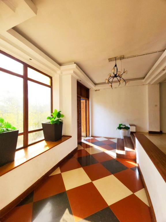 a living room with a checkered floor and windows at Pendo suite in Nairobi