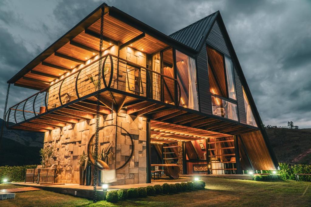 a house built out of wood with a tower at Chalé RIVAGI in Passa Quatro