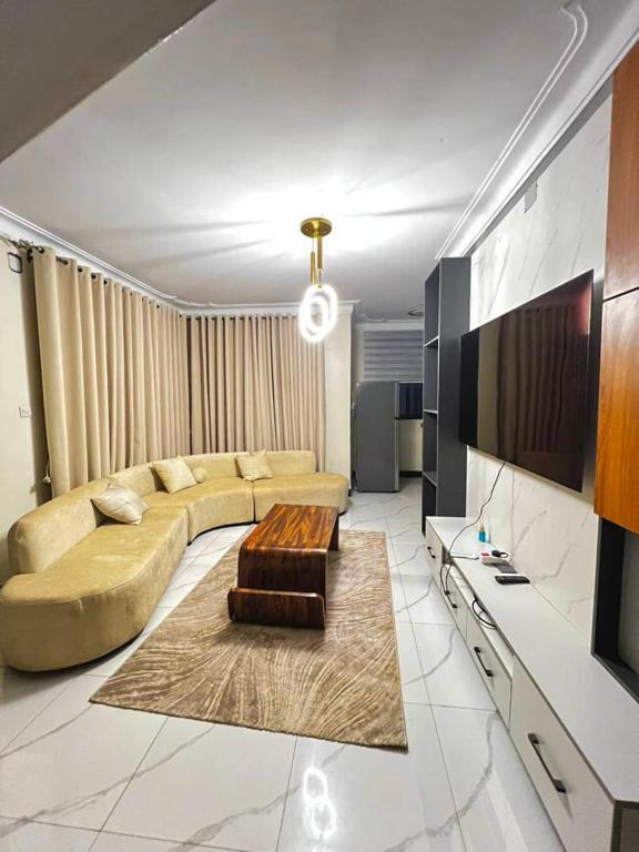 a living room with a couch and a tv at Sunset Statehouse View Residence A in Entebbe