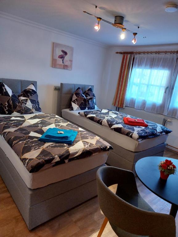 two beds in a room with a table and chairs at Apartment Voithofer in Wald im Pinzgau