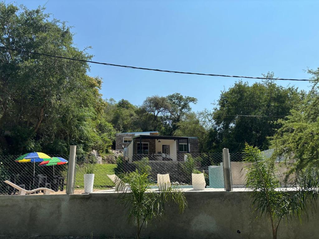 a garden with a house and an umbrella at CerroMio! in Villa Serranita