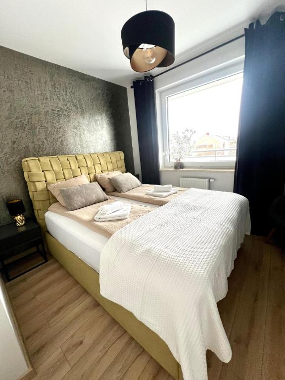 a bedroom with a large bed and a window at SPV Rentals Pileckiego 59 lokal 226 free Parking Ursynów in Warsaw