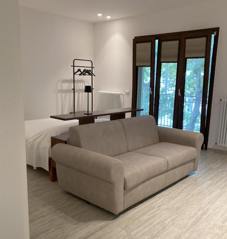 a living room with a couch and a bed at Serena a due passi dal mare in Bellaria-Igea Marina
