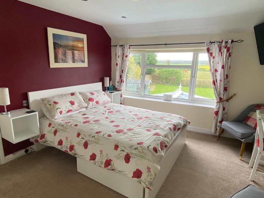 a bedroom with a bed and a window at Brambling Fields B&B and Cottages in Malton