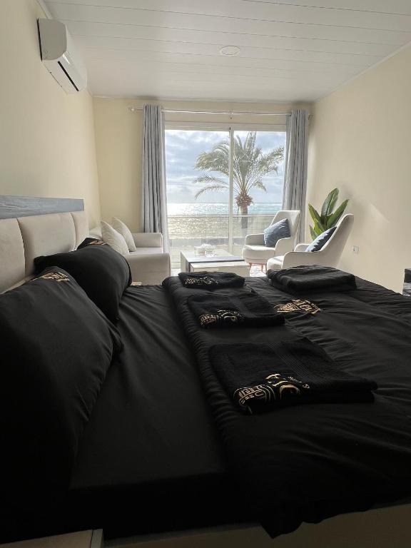 a bedroom with a bed with a view of the beach at voya hotel and suites in Soûr