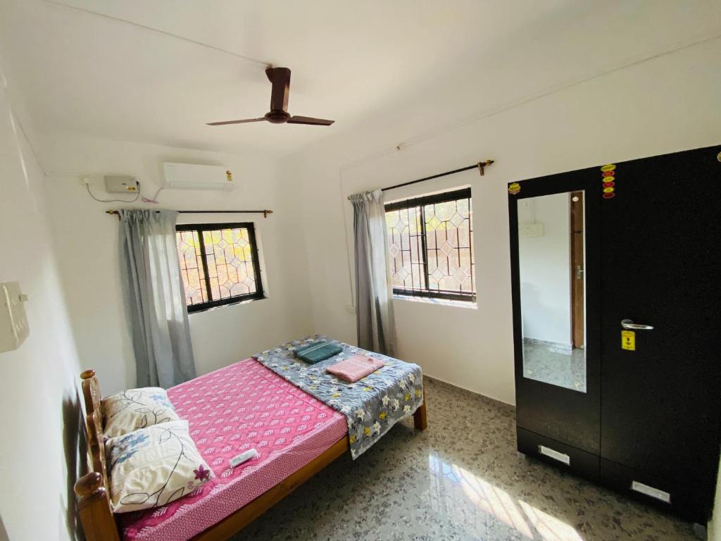 a small bedroom with a bed and a ceiling at HoneyBee 2BHK Homestay Agonda in Agonda
