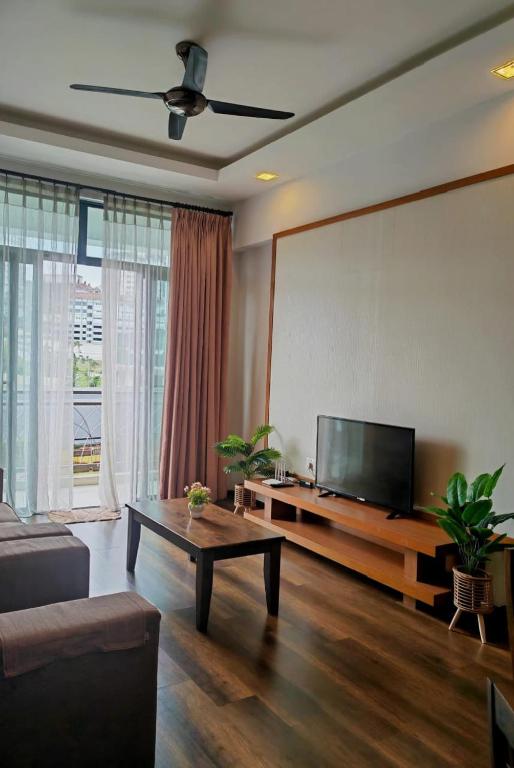 a living room with a couch and a flat screen tv at Bayt Rizq Homestay 3R2B in Brinchang