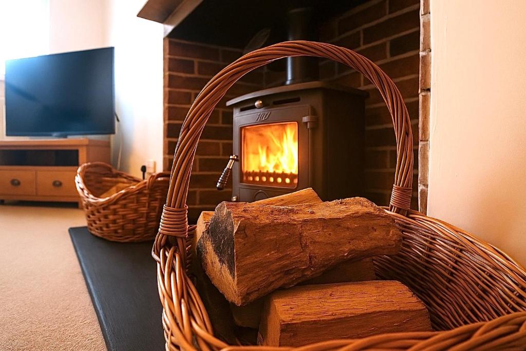 a basket with logs in front of a fireplace at The Place in Johnshaven