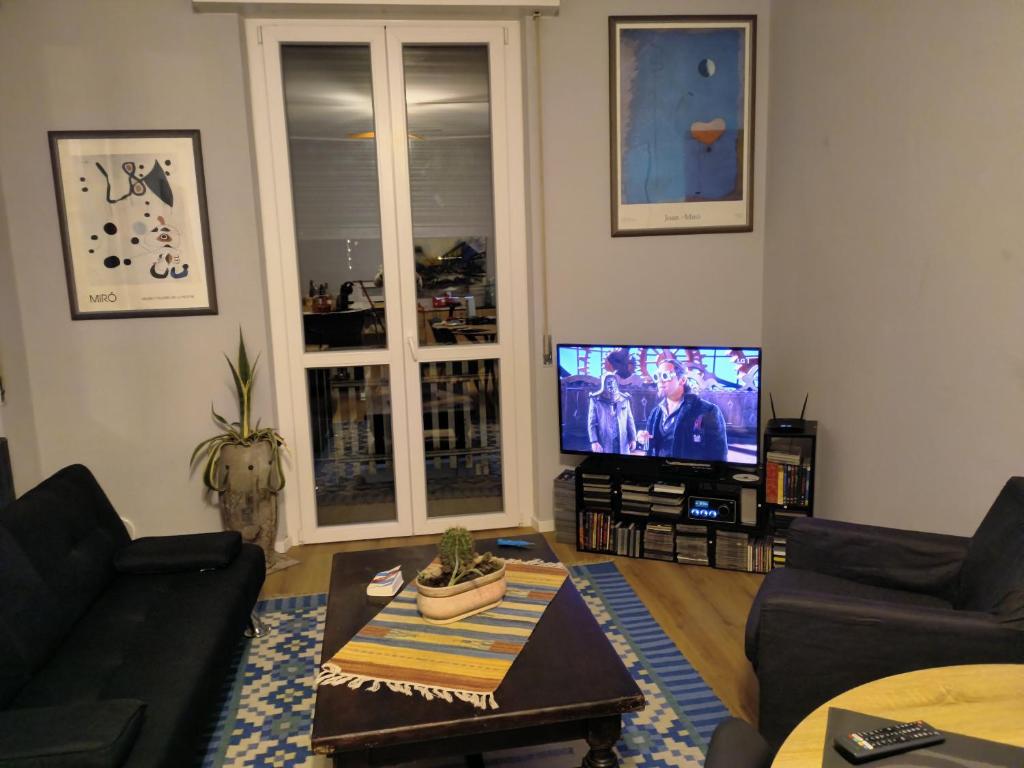 a living room with a couch and a flat screen tv at Dolcecasa15 in Sannazzaro deʼ Burgondi