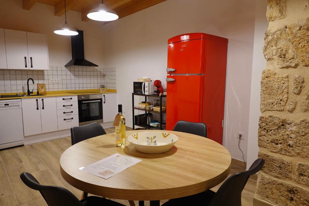 a kitchen with a wooden table and a red refrigerator at Casa Paulina in Beceite