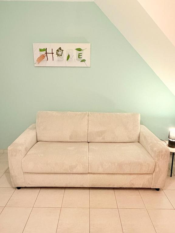 a couch in a living room with a painting on the wall at Refuge idéal in Digoin