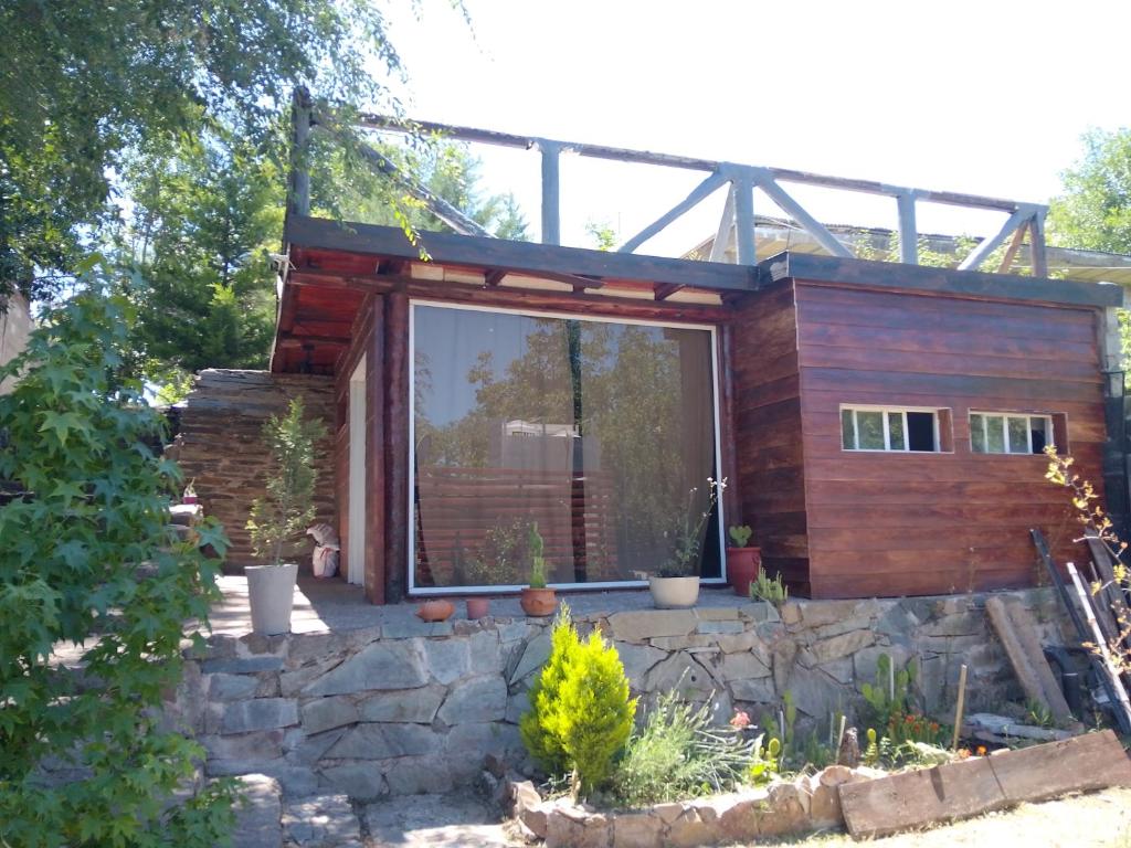 a house with a large window on a stone wall at Espacio de relax in Trapiche