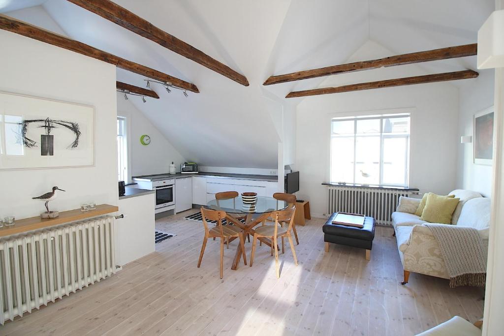 a living room with a table and a kitchen at The Viking s Haven - Heart of Downtown in Reykjavík