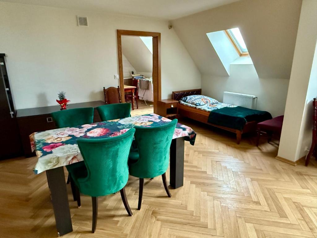 a room with a table and chairs and a bed at Peter House in Nowy Targ