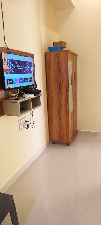 a room with a computer and a wooden cabinet at Rk comforts & lodge in Madhugiri