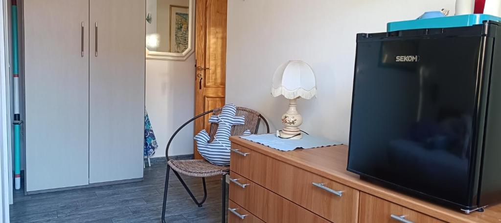 telewizor na komodzie z lampą na nim w obiekcie Fabienne w mieście Bonassola