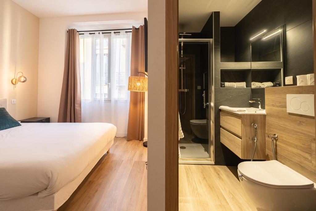 a hotel room with a bed and a bathroom at Chambre 5 La Baieta in Nice