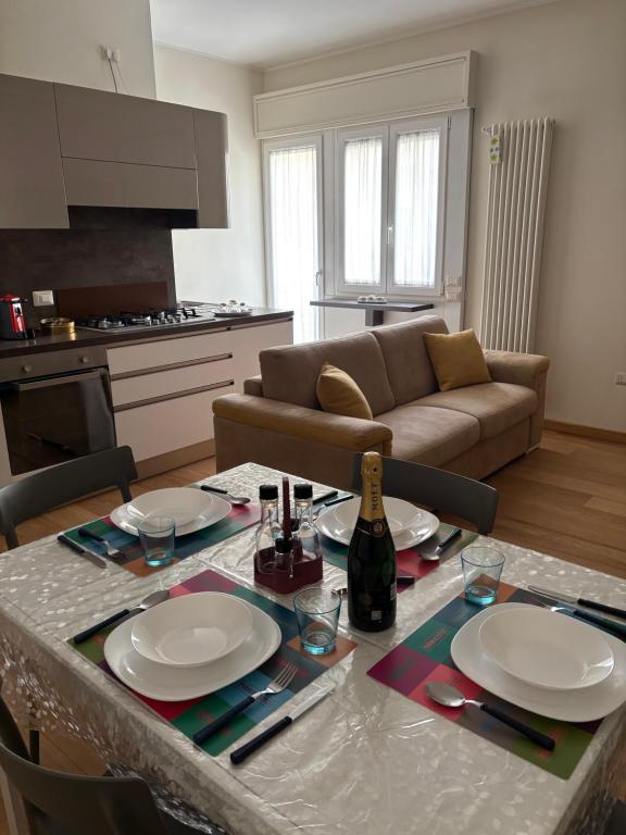 a living room with a table with plates and a bottle of wine at Fortunato Casa Vacanze in Matera