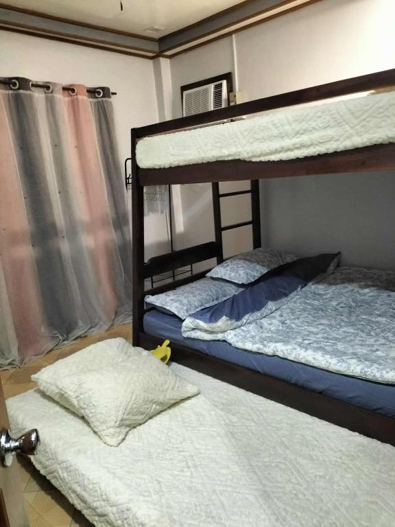 a bedroom with two bunk beds and a window at Naybe's Room rentals in Dapa