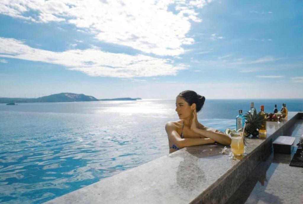 a woman sitting in a pool with the water at Apec Mandala Ocean Retreat- Mui Ne in Mui Ne
