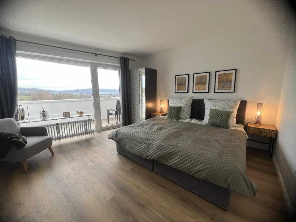 a bedroom with a large bed and a large window at Bella Vista Studio-Appartement in Bad Rothenfelde
