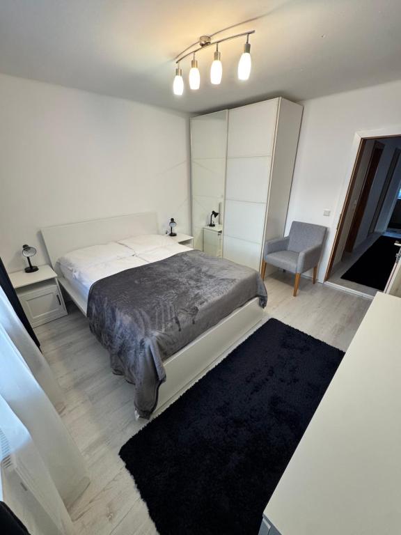 a bedroom with a large bed and a chair at Oberalm Apartment Gemütliche 2 Zimmer Wohnung in Oberalm