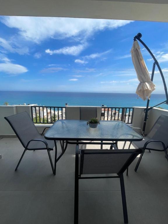 a table and chairs on a balcony with the ocean at Mirtos4seasons in Myrtos
