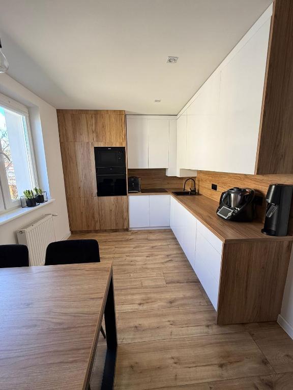 a kitchen with white cabinets and a wooden counter top at AgA in Pobierowo