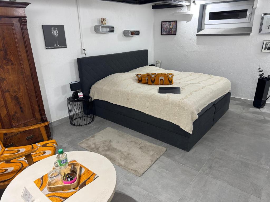 a bedroom with a large bed and a table at Gemütliches Kellerzimmer + Bad in Bocholt