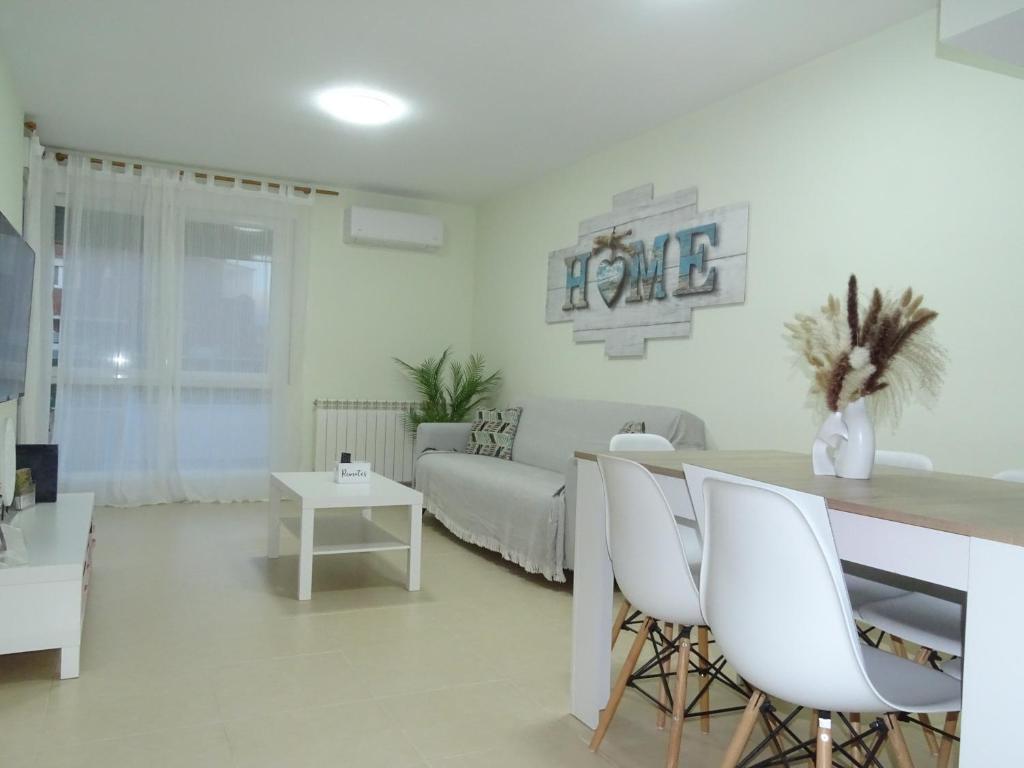 ein Wohnzimmer mit Sofa, Tisch und Stühlen in der Unterkunft Brezo 2 in Yunquera de Henares