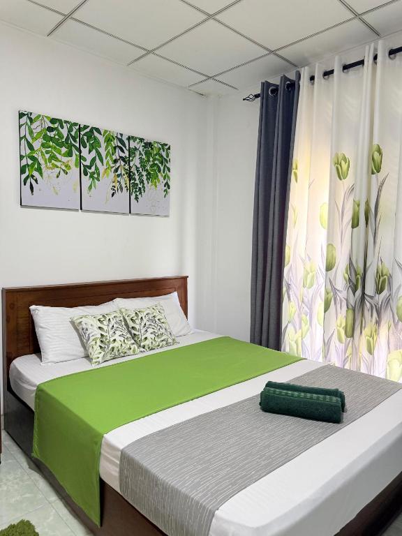 a bedroom with a large bed with a green blanket at Sonora in Kandy