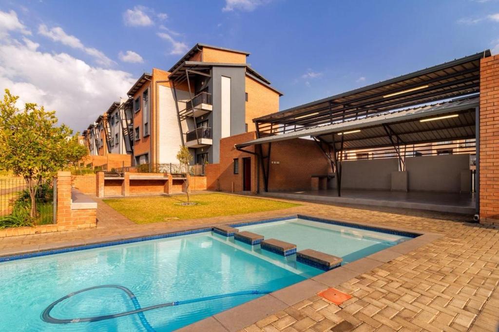 a large swimming pool in front of a building at The Waterfallcity Charm next to Mall of Africa in Midrand