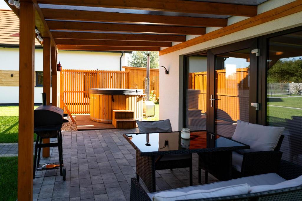 a patio with a grill and a table and chairs at Dom z balią in Mikołajki