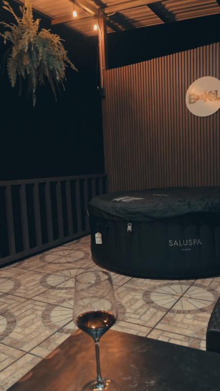 a wine glass sitting on a table next to a suitcase at Cabaña BosKaL in Quesada