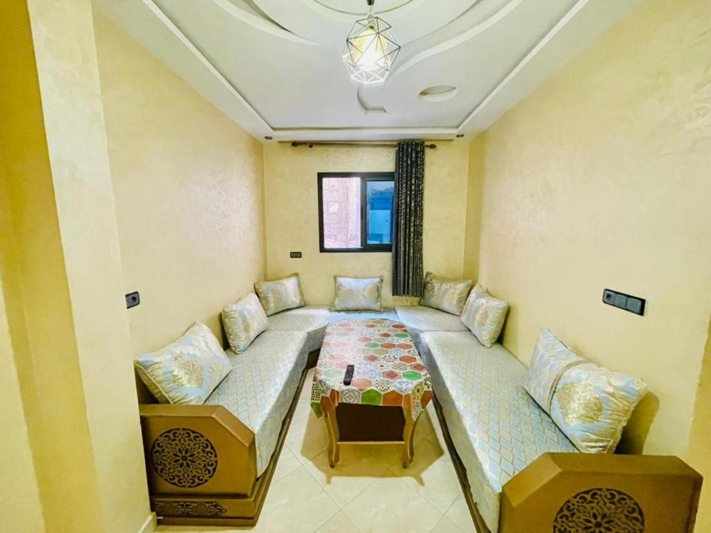 a living room with a couch and a table at Waves Surf House in Taghazout