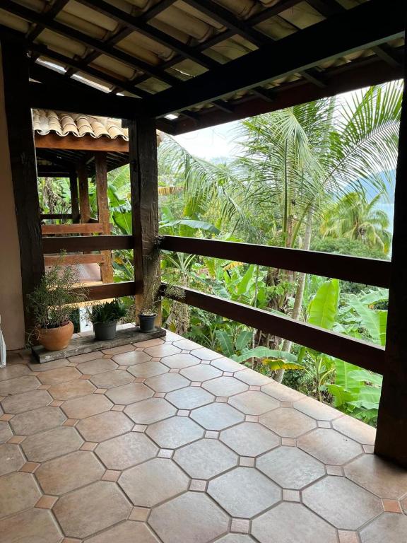 a porch of a house with trees and plants at Canto do Cururuá - IlhaBela in Ilhabela